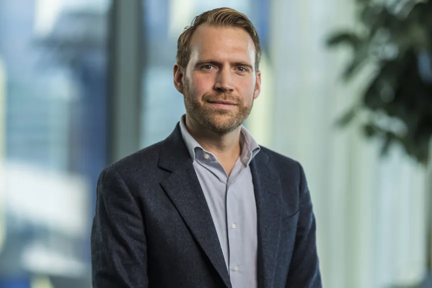 Porträtt på Albin Falkmer. Han bär en mörk kavaj och blå skjorta.