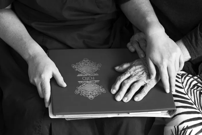 Emma och vårdtagare tittar i fotoalbum