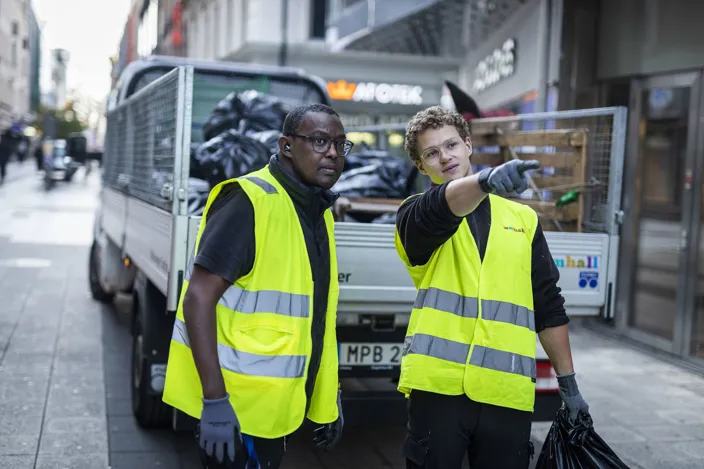 Två Samhallsanställda som står bredvid varandra på en gata.