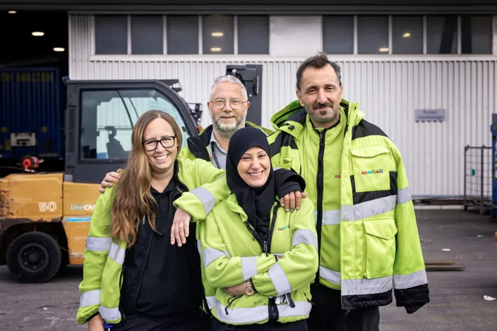 Medarbetarbild på fyra personer bärandes reflexjackor. Alla tittar in i kameran och ler. 