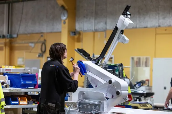 Samhallsmedarbetare rengör en gynstol i en vårdmiljö.