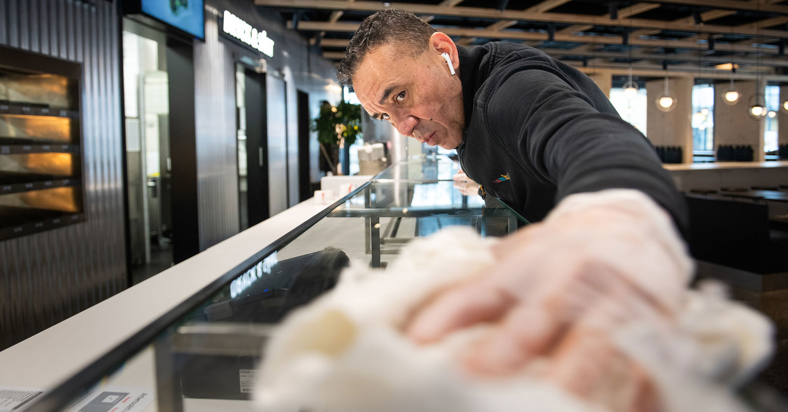 Humberto Rengifo putsar kassadiskens glas med en trasa.