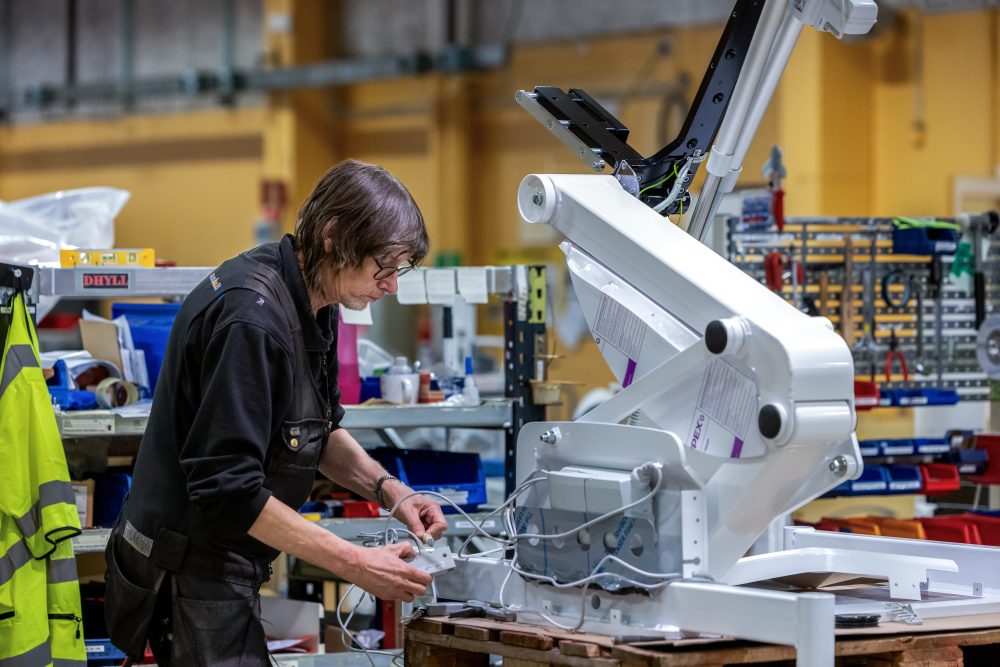 Samhallsmedarbetare rengör och hanterar medicinsk utrustning i en vårdmiljö.