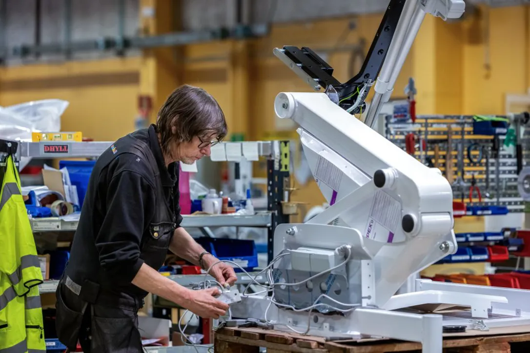 Samhallsmedarbetare rengör och hanterar medicinsk utrustning i en vårdmiljö.