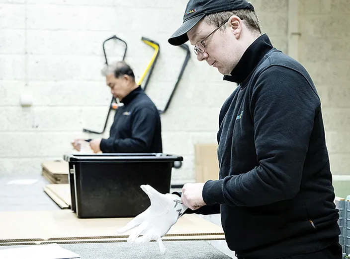 Samhallsmedarbetare tar på sig en handske.