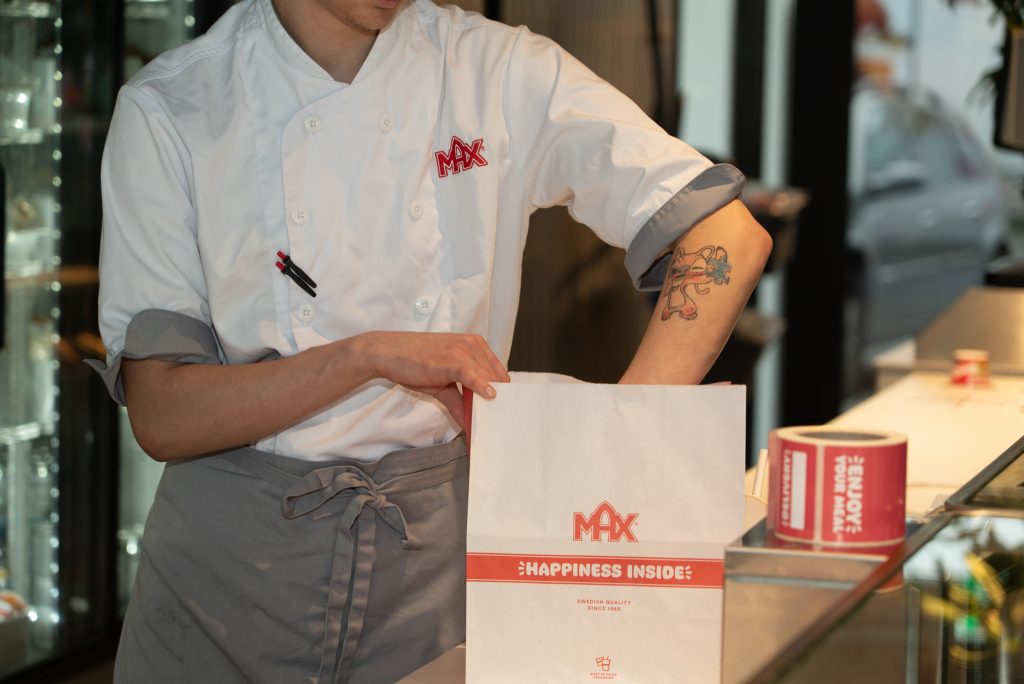 Samhallsmedarbetare arbetar i köket på en Max-restaurang och förbereder mat.