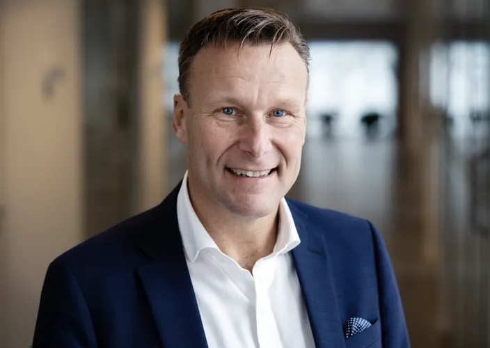 Porträtt av Henric Ungh, vd på Beneli, som led och tittar in i kameran. han bär en mörkblå kavaj och vit skjorta. 