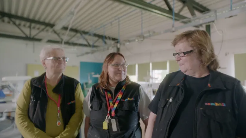 Tre personer med samhall-kläder.