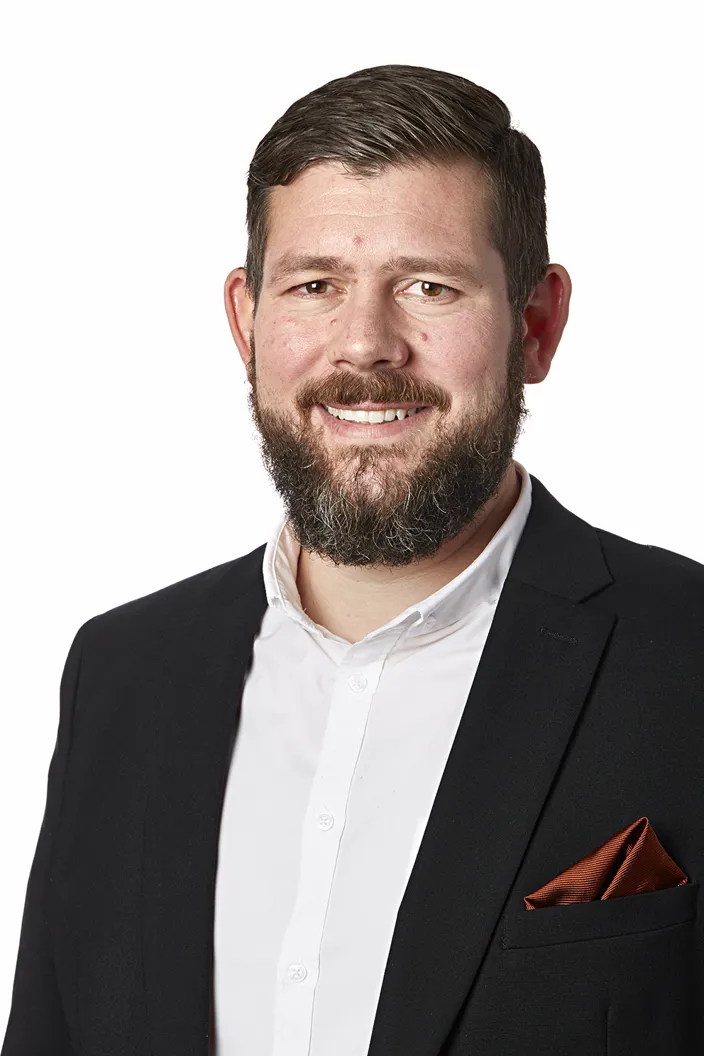 Porträtt av Erik Olsson Wahman. Han bär vit skjorta och svart kostym. 